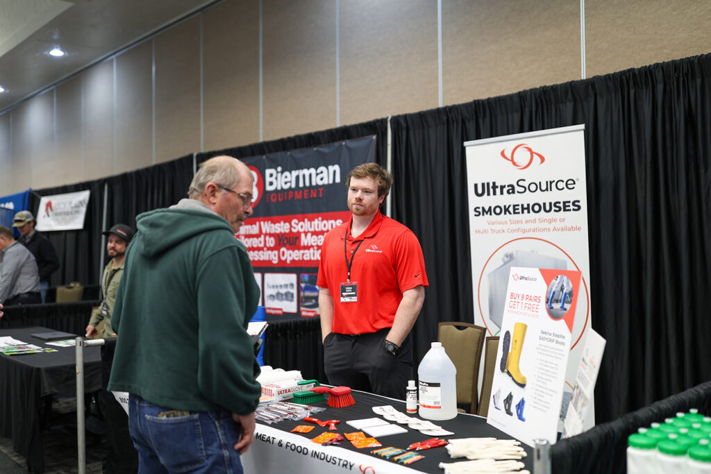 NDAMP 2025 Vendor Tradeshow. Vendor talking with a potential customer.